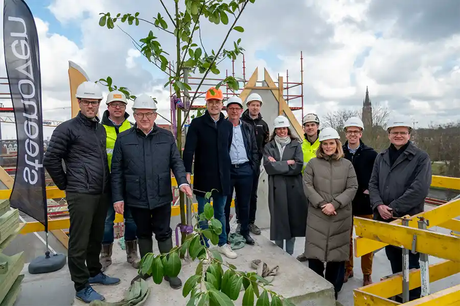 Burgemeester De fauw plant meiboom op hoogste gebouw van klimaatvriendelijke woonbuurt Boevrie